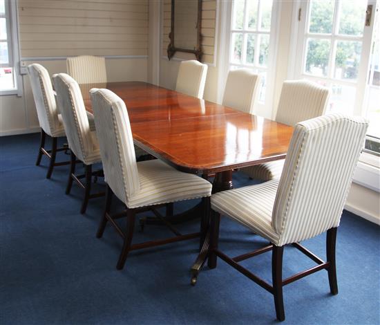 A cross banded and strung mahogany triple pillar extending dining table and a set of eight dining chairs,